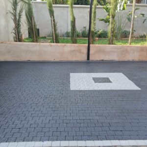 Square cobbles paving blocks on a modern black driveway with white centre pattern – Cabro Blocks Kenya